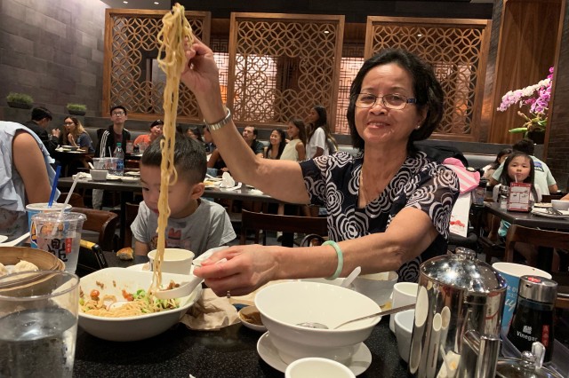 Woman pulling noodles at restaurant 