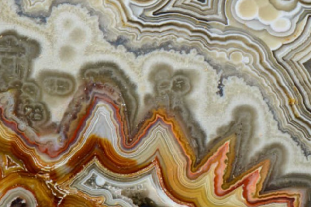 Orange, gray and beige wavy patterns in a mineral