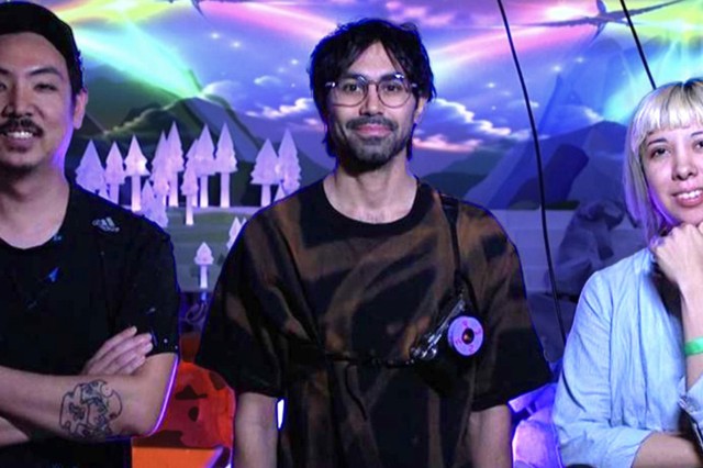RFX1 (Jason Chang), Joel Fernando, and Yesenia Prieto in front of a glowing projected mountains, clouds, and trees in purple, blue, and green