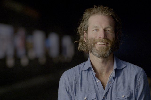 Ronan Donovan from the shoulders up, with light red hair and beard and wearing s sky blue shirt